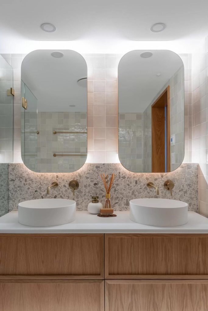 Modern bathroom  with back light mirrors and stone pattern splashback