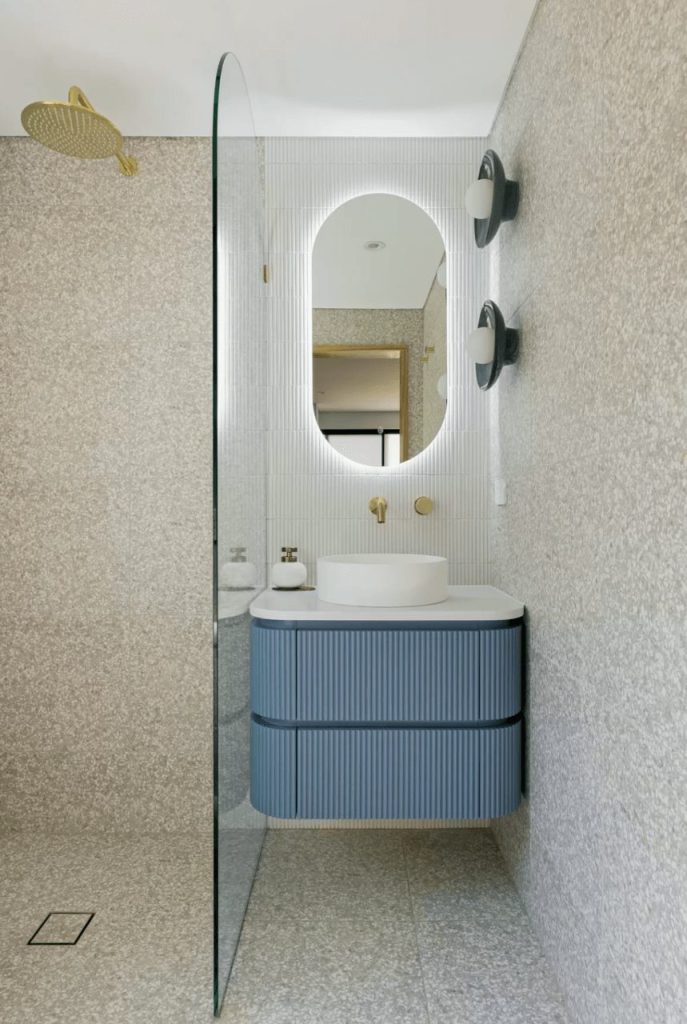 Modern bathroom with wall  sconces and speckled tiles