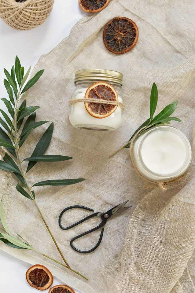 leaves, dried oranges, jars and other items for making candles