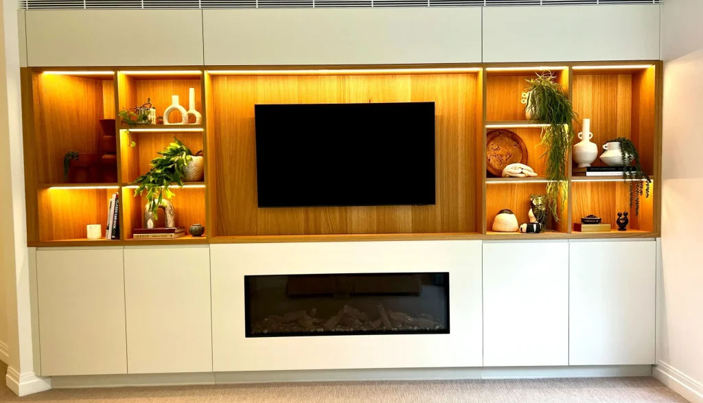 Custom designed media wall incorporating display shelves, integrated lighting and fire place in a full home renovation in Turramurra Sydney
