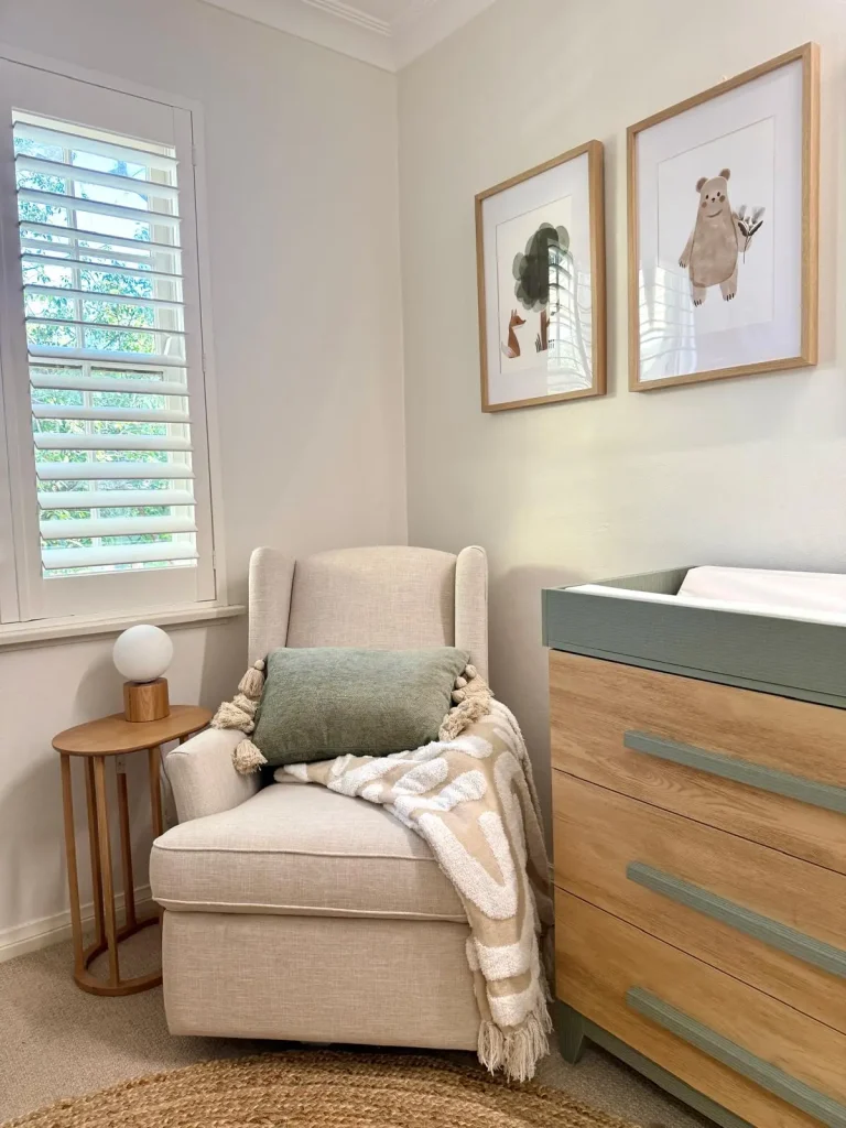 Nursing chair and change table draws with sage green highlights.